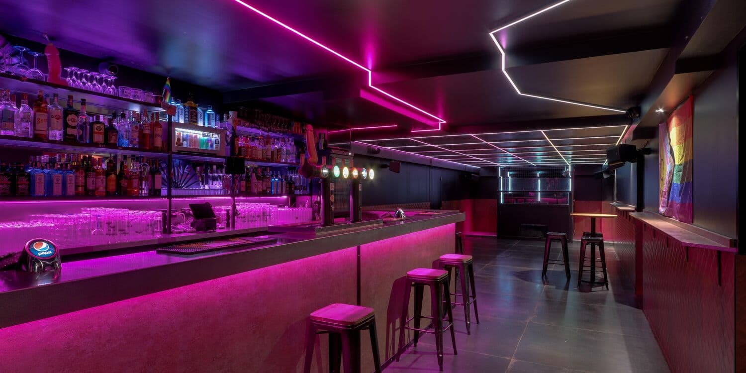 Comptoir et tabourets sous les lumières violettes